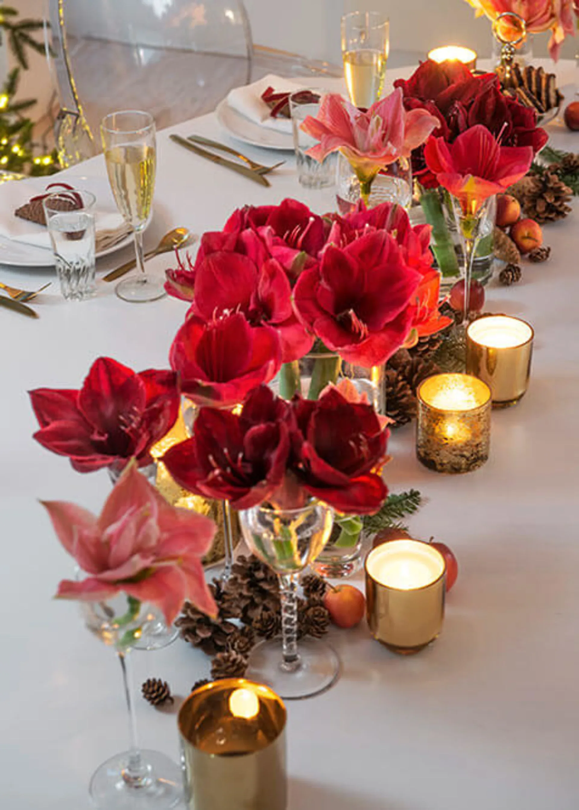 Julebord pyntet med røde blomster og levende lys